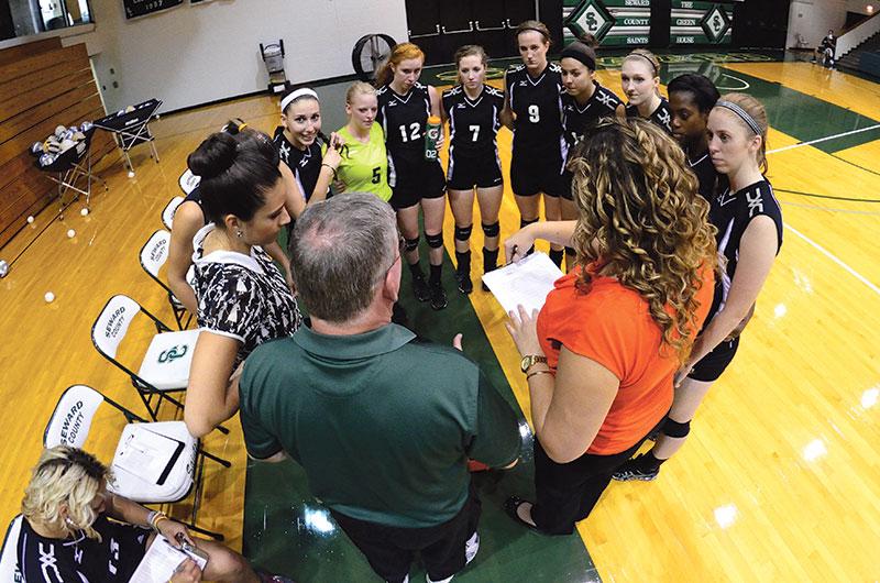 Crusader photo/Jakub Stepanovic
The 2013-2014 Lady Saints volleyball team huddle with head coach Bert Luallen. The Lady Saints ended their season with a winning record of 22-17 and fourth place at the Region VI Championship Tournament.­ 