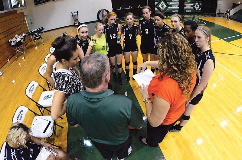 Crusader photo/Jakub Stepanovic The 2013-2014 Lady Saints volleyball team huddle with head coach Bert Luallen. The Lady Saints ended their season with a winning record of 22-17 and fourth place at the Region VI Championship Tournament.­ 