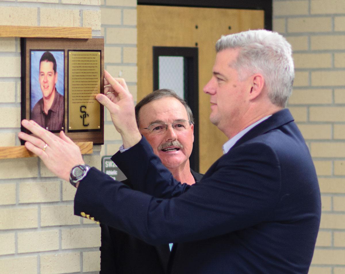 Crusader photo/ Jakub Stepanovic
Pat Stangle adds his plaque to the Hall of Fame wall. Stangle, the win- ningest volleyball coach in Seward history, was inducted into the Hall of Fame Friday before the Athletic Banquet.