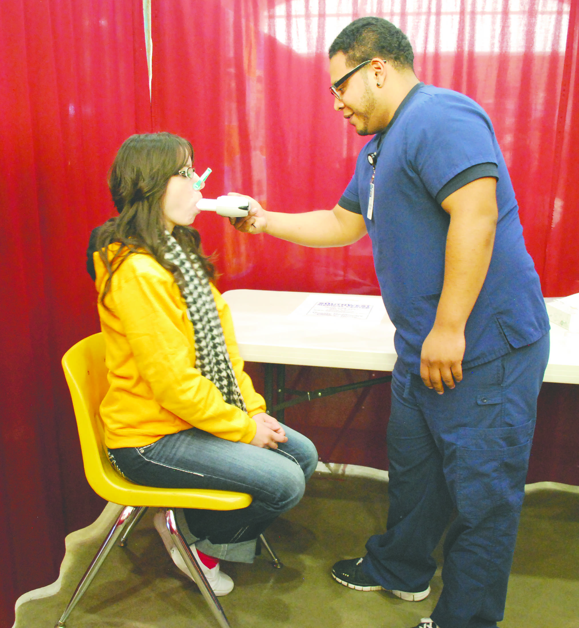 Giovanna Baca, Miss Liberal and former SCCC/ATS student, gets her lungs checked by SCCC/ATS respiratory student Jose Vidal at the health fair Saturday.