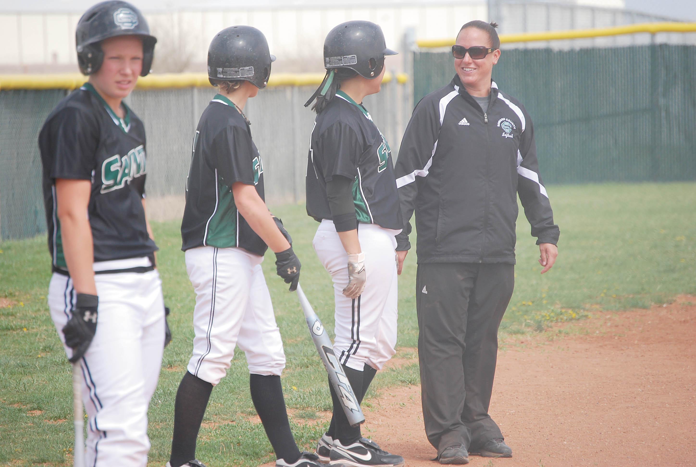 Softball coach Andrea Gustafson shares a moment with two Seward County players. Gustafson recorded the 300th win of her collegiate coaching career April 10. 
