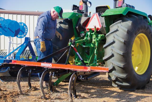 Crusader photo/Maria Lara David Coltrain, Sustainable Agriculture Resources Program Specialist, works on Seward County’s tractor yesterday afternoon, attaching the chisel plow, in preparation to start plowing rows. Students and Coltrain will start planting cool season produce in the next couple of weeks. 