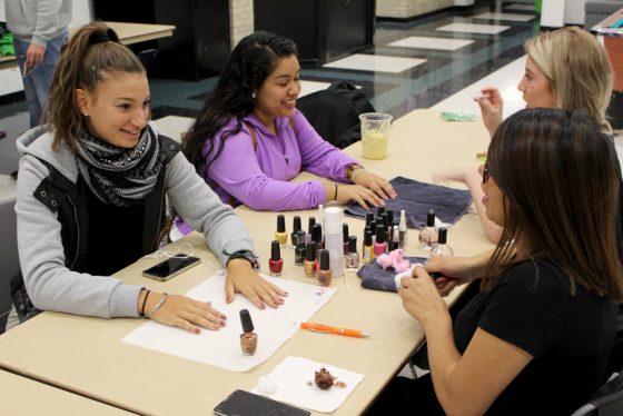 Tennis player Sarah Manseri is treating herself to a manicure provided by a Cosmetology student.