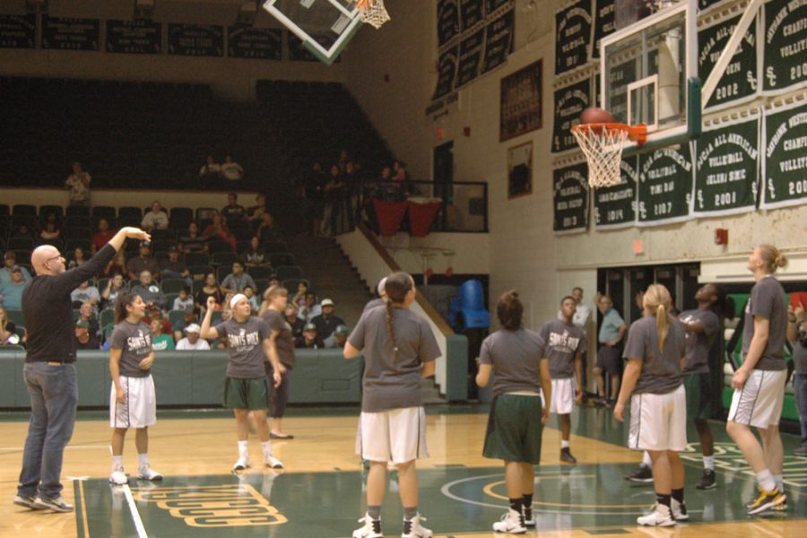 Women's basketball coach Toby Wynn scores a shot in the free throw competition against the Men's team. This year's competition went to the Men's team with a final score of 33-24.