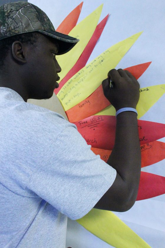 Kenny Holmes, HVAC student, writes what he is thankful for on the Admissions bulletin board.