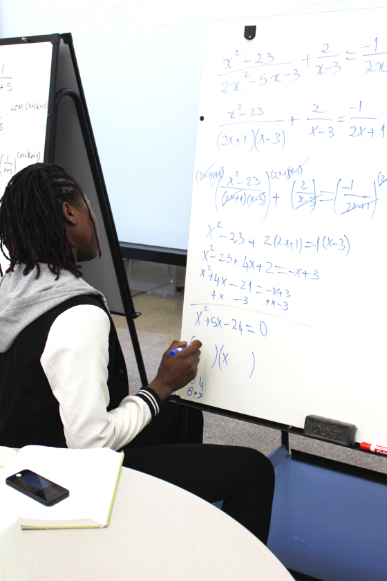 Women’s basketball player Manuela Fungate works on problem on the whiteboard to practice her math skills.