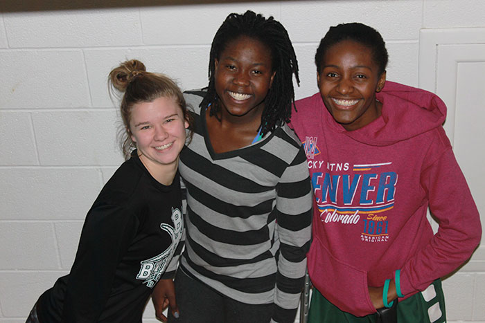 Teammates Erin Richardson,Manuela Fungate, and Clitan de Sousa smile big for the camera.
