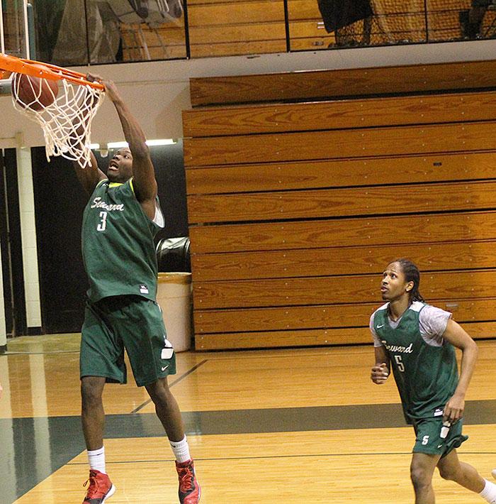 Sophomore Ernest Carter, finishes a play with a slam dunk from a assist from teammate Jeromie Simmons. 