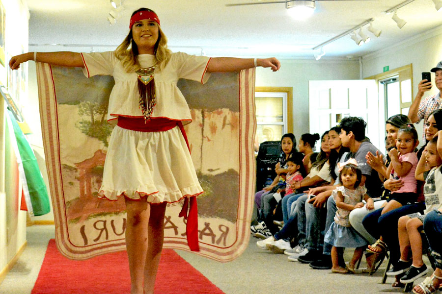 Sarahi Aguilera struts down the runway showing off her outfit. The Baker Arts Center put together a fashion show to highlight different cultures and styles in honor of Hispanic Heritage month that runs from Sept. 15- Oct. 15.