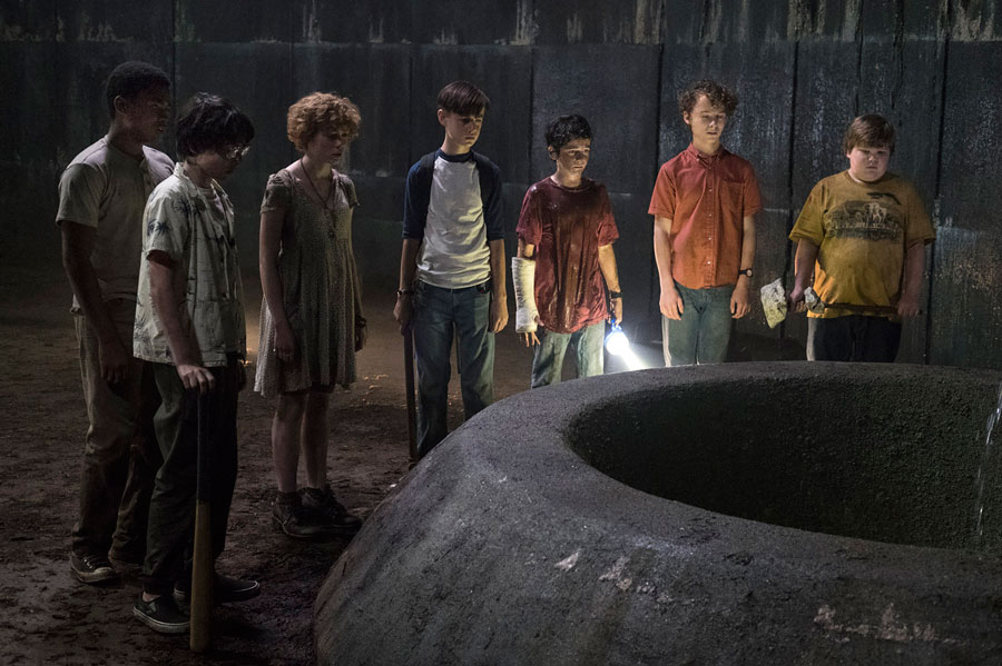 The seven children from the movie watch Pennywise descend down the tunnel. 