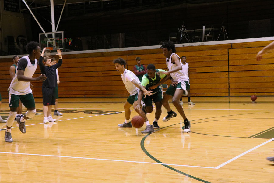 Freshman Jamel Horton attempts to dribble in between defenders Anthony Thomas and Isiah Small. The team was scrimmaging half-court and mainly focusing on attacking to the basket. 