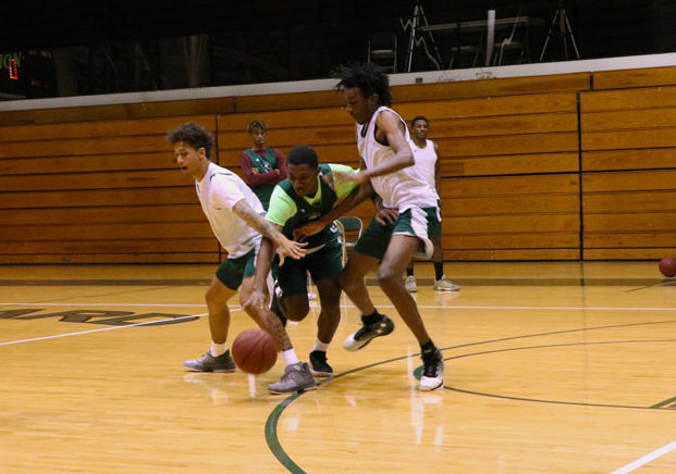 Freshman Jamel Horton attempts to dribble in between defenders Anthony Thomas and Isiah Small. The team was scrimmaging half-court and mainly focusing on attacking to the basket.