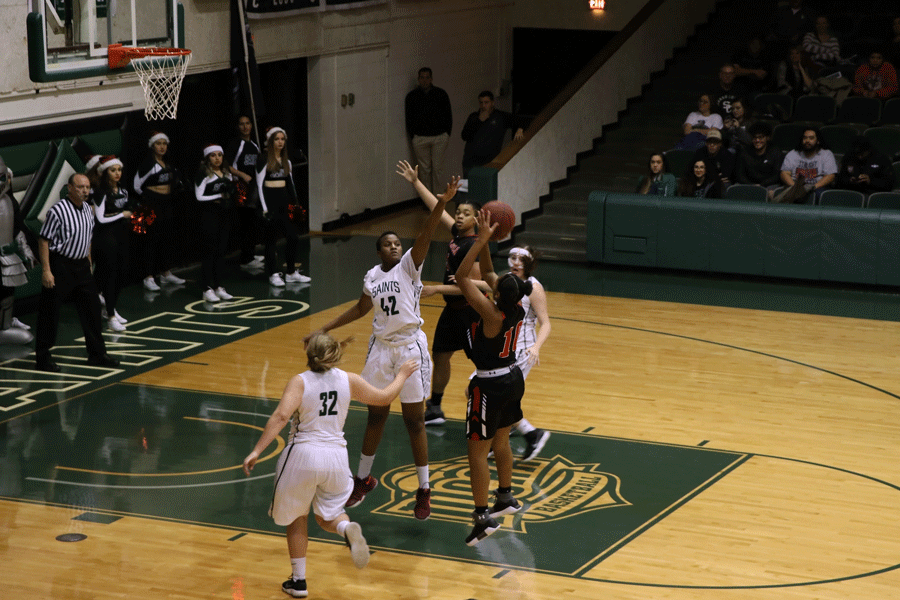 Freshman Carla Covane blocks a Red Devils shot during the first half. Carla Covane finished the game with 11 points, seven rebounds, two assists and steals.  