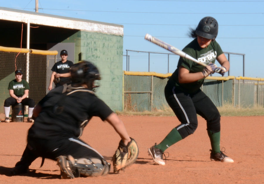 Sophomore right-handed pitcher, Monique Ashley,  watches a ball go past her while sophomore catcher, Miriam Hirata, catches the softball.