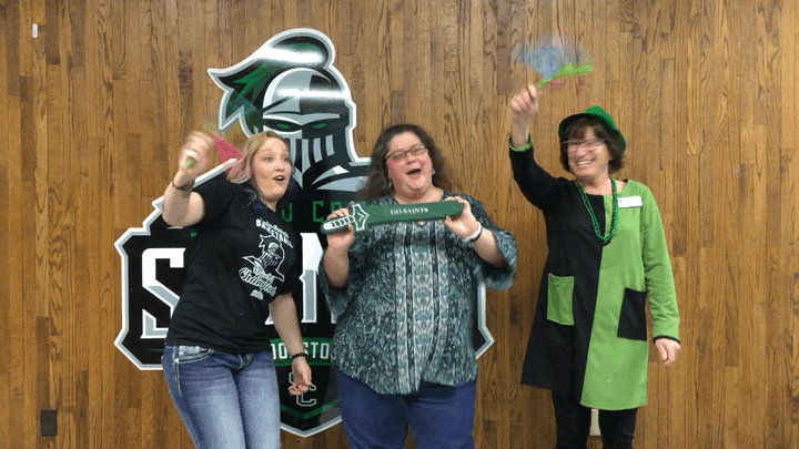 Fans used foam swords and hand clappers to cheer on the Lady Saints. The registrars office Krystal Zimmerman and Alaina Rice rock the dance moves with Celeste Donovan, vice-president of student services.