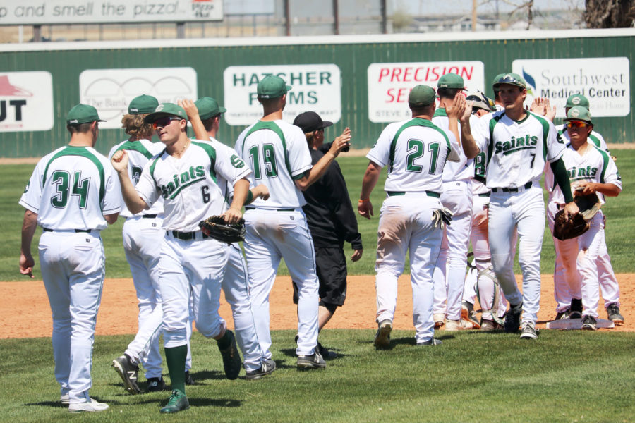 The Saints baseball team comes together and congratulates one another after their 8-2 win over the Blue Dragons.