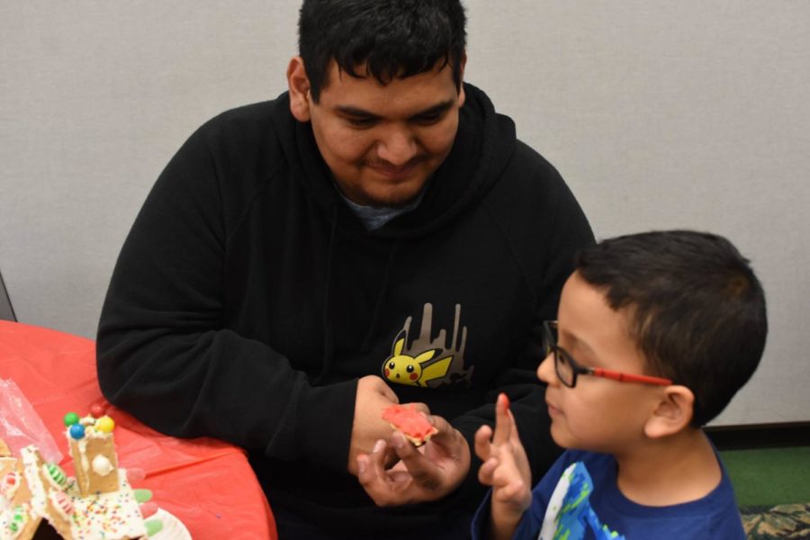 Danny Vasquez, Liberal drafting major, helps a grade schooler build a gingerbread house. Vasquez is part of the new club, Circle K International. The club is dedicated to community service and helping others.