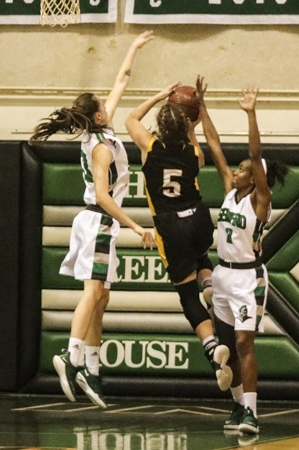 The Lady Saints form a wall at the baseline to keep Cloud Countys Scout Frame from scoring. Seward went on to win by a large margin, 80-57.