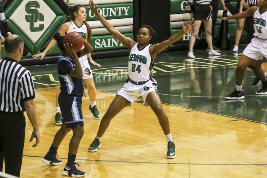 Vonda Cuamba plays good defense to help the Lady Saints defeat the Lady Trojans, 65-60. The win extended their win streak to 19 in a row.