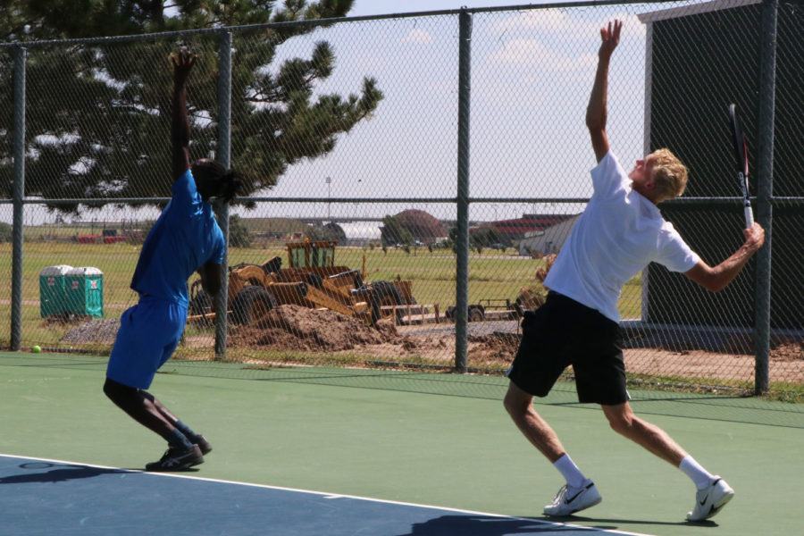 Sophomore Sander Jans and freshman Nil Moinet, focus on how high they have to throw the tennis ball in the air for them to get a good serve. 