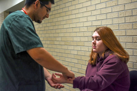 Jaime Torres practices taking pulse and blood pressure. The Liberal nursing major chose to ignore the masculinity stigma of male nurses by focussing on his passion for caregiving.