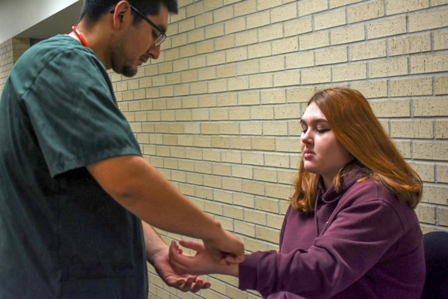 Jaime Torres practices taking pulse and blood pressure. The Liberal nursing major chose to ignore the masculinity stigma of male nurses by focussing on his passion for caregiving.

