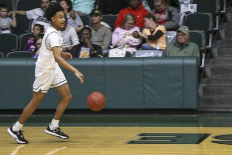 Samuel Henderson brings the ball down the court during a game. The freshman guard has helped the team to a 12-9 overall record.
