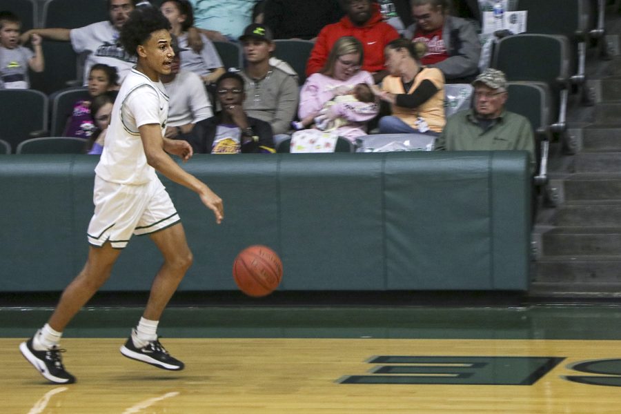 Samuel Henderson brings the ball down the court during a game. The  freshman guard has helped the team to a  12-9 overall record.