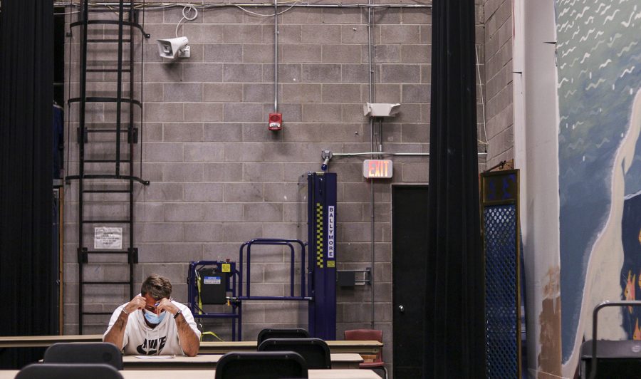 Pierre Copin, a sophomore from France sits in the Showcase Theater for his midterm for public speaking. For many students sitting six feet apart during classes and tests have become the new “normal” 
