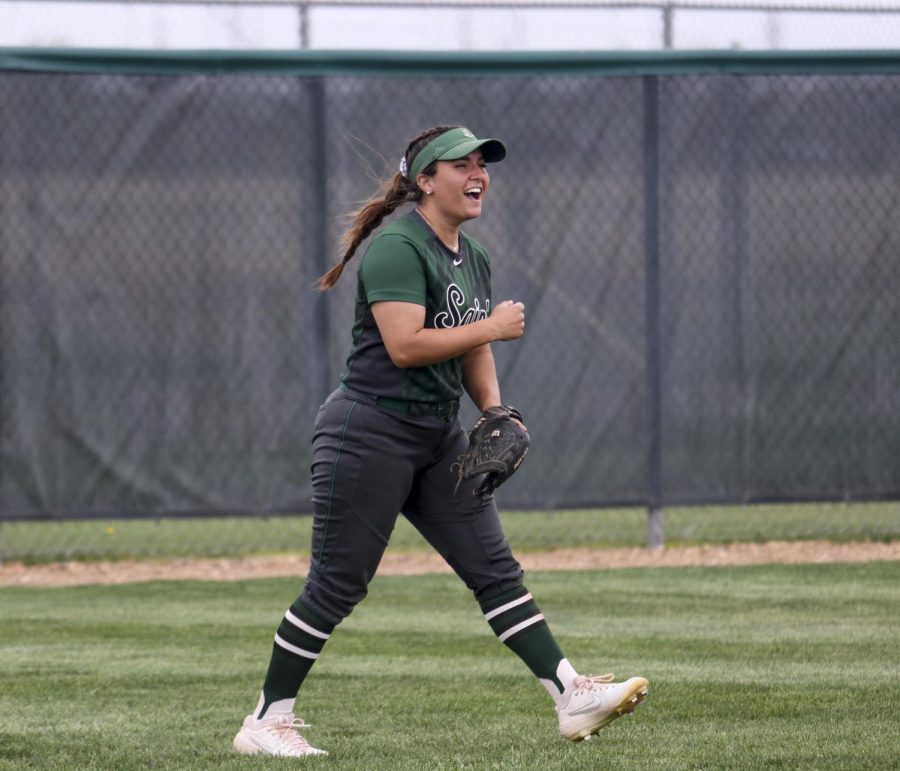 Jacie Scott, left fielder, cheers as her teammate and pitcher, Ireland Caro, gets the last strikeout of the inning. This pitch gave the Lady Saints an 8-6 win for game two of the doubleheader against Garden City. 