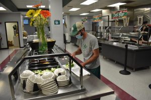 Staff personnel Paul Fisher making a salad with the newly open salad bar.
