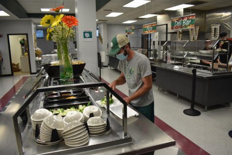 Staff personnel Paul Fisher making a salad with the newly open salad bar.
