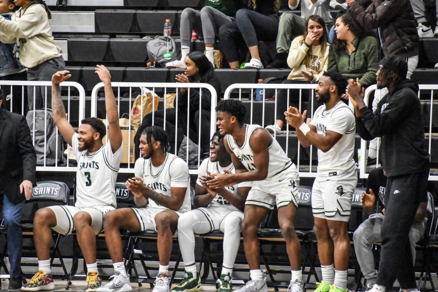 The+Saints+bench+erupts+in+cheers+as+a+teammate+throws+down+a+dunk+in+the+68-61+win+against+Dodge+City+Community+College+Wednesday+in+the+Green+House.