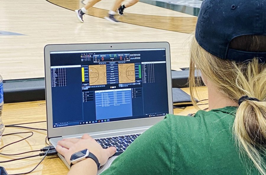 Locked in during the first quarter, Tatum Winters scans the court in search of the ball to prepare the stats. Working behind the bench, she hovers over the digital court on the screen ready to input if a shot is made or missed. 