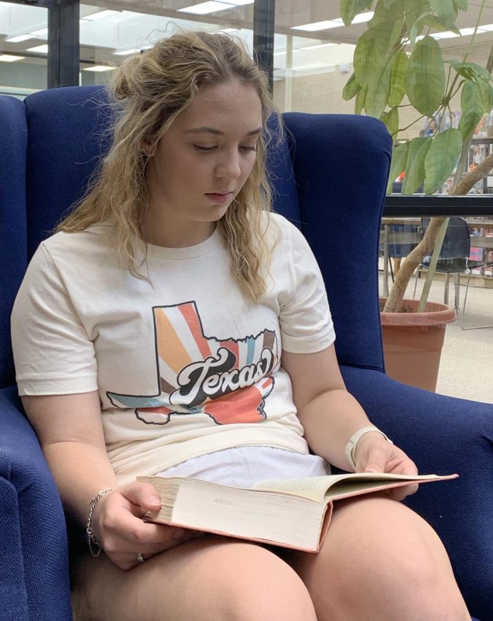 Sitting in the library, Franklin reads a book to learn more about nursing. Franklin studies in her free time so she can get good grades and pass nursing school.
