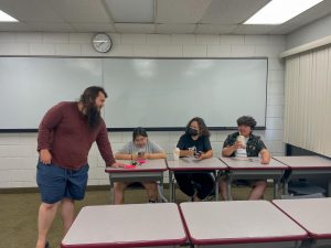 Anime club members Alexis Soto, Judith Soto, and Alexa Pavia discuss with Michael McComack, president of the club, about future endeavors. The club is interested in taking a trip to an anime convention.