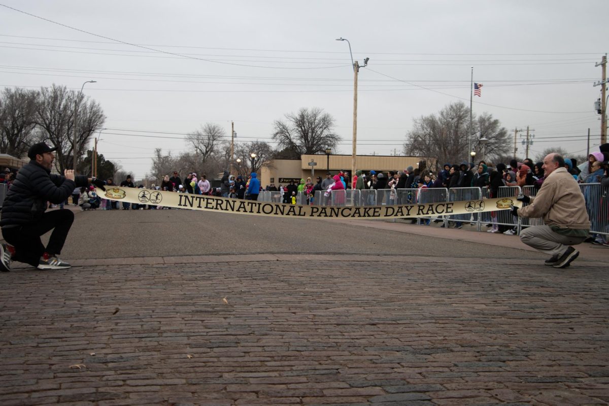 Ben Scantlin and Frank Hampton hold up the International Pancake Day Race banner at the finish line. This banner was just introduced to Pancake Day in 2024.