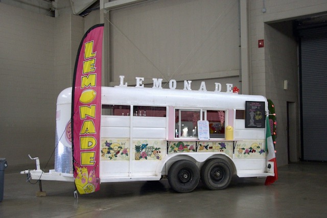 The festive Sugar Daze lemonade stand, complete with bright decorations and a colorful menu, offers refreshing drinks to attendees at the event.