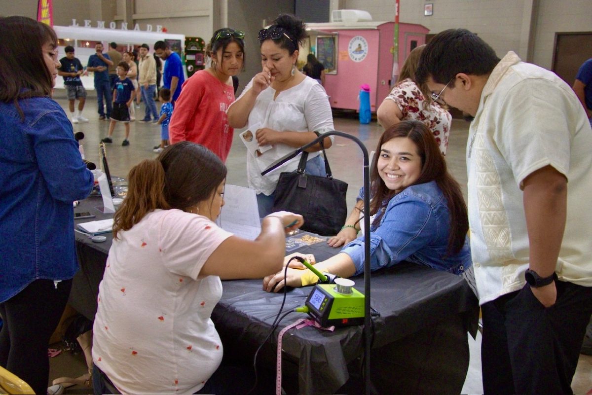Ruth Rivera smiles while getting a permanent bracelet by Permanent Moonlight Jewelry during the Celebrate and Connect Fest, hosted by HALO at the Seward County Activity Center.
