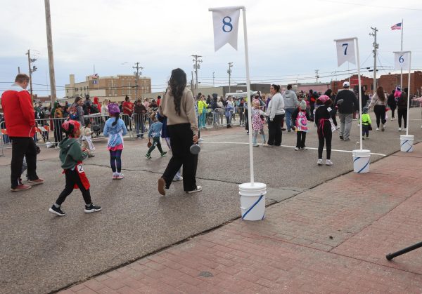 Parents walk their children to the starting line for the Pancake Day youth races. Families gathered downtown to support the racers.