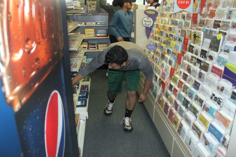 Emanuel Serrano, student at SCCC, searches for a special prize egg in the shelves of the bookstore.