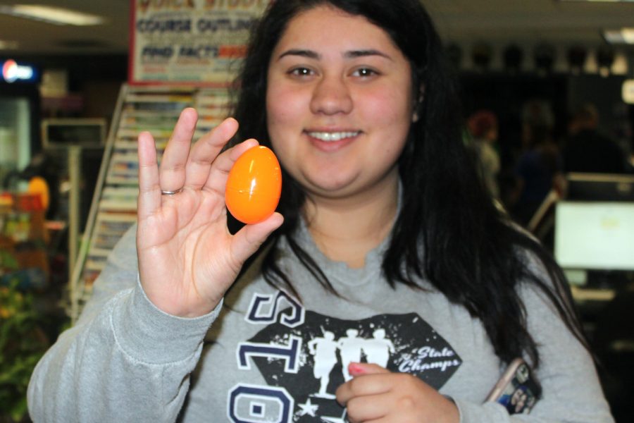 Magali shows off her egg she found in the bookstore. Eggs were scattered around the bookstore and outside the bookstore.