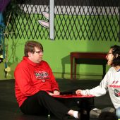 Lucy Can Pelt, played by Biviana Rodriguez, attempts to flirt with Schroeder, played by David Adams, while he is playing the piano.