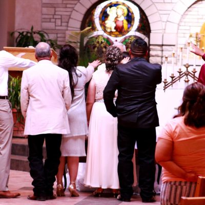 Family gathers around Bryanna Banuelos to pray for her. Dedicating a young woman to God is all part of the traditional quinceanera ceremony in Southwest Kansas.