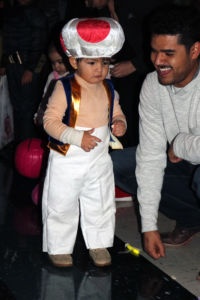 Andres Dominguez watches his pumpkin roll down the bowling lane towards the toilet paper bowling pins. Dominguez was dressed at Toad from Super Mario.