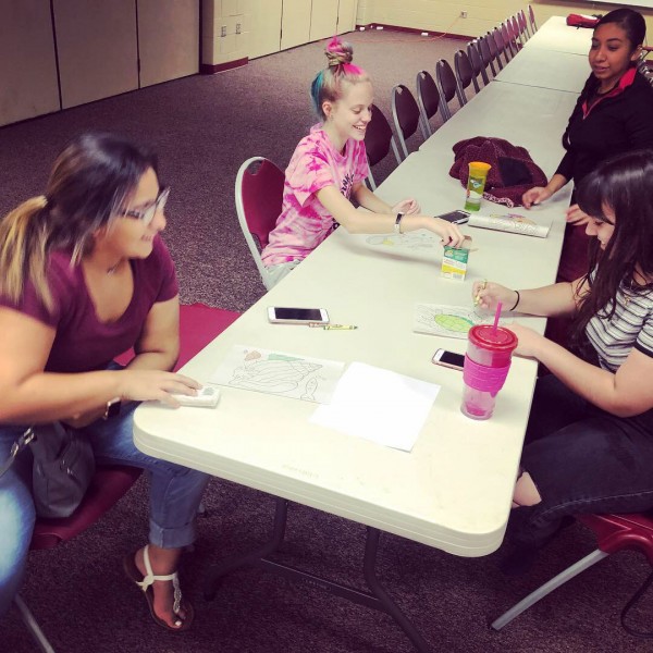 Coloring is not just for kids. Crusader staffers, Monica Gonzalez, Annette Meza, Anastasia Smalldridge and Rubi Gallegos, color while they wait for children to arrive. Crusader worked as babysitters at the annual SCCC Foundation auction.
