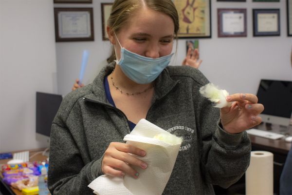 Krisi Anderson, a freshman majoring in history, eats freshly made cotton candy during Crusader class.