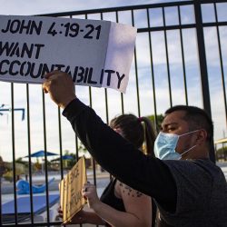 A protester shows off his sign to drivers passing by as he walked north on 11th. The peaceful march was open the entire community last summer.